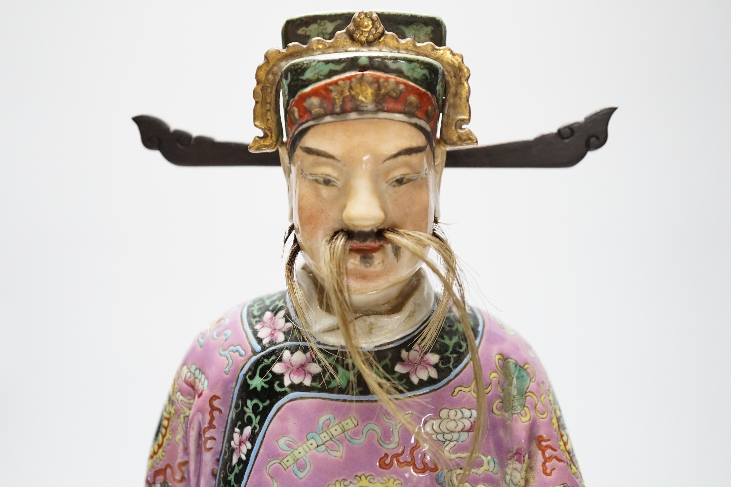 An early 20th century Chinese enamelled porcelain figure of an immortal, 31.5 cm high
